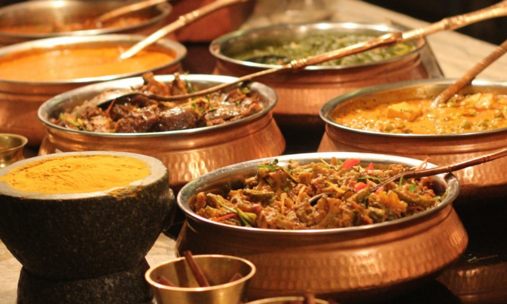 Authentic Indian food spread with curries, naan, and traditional copper serving bowls at Bombay Kitchen and Bar in Vancouver.