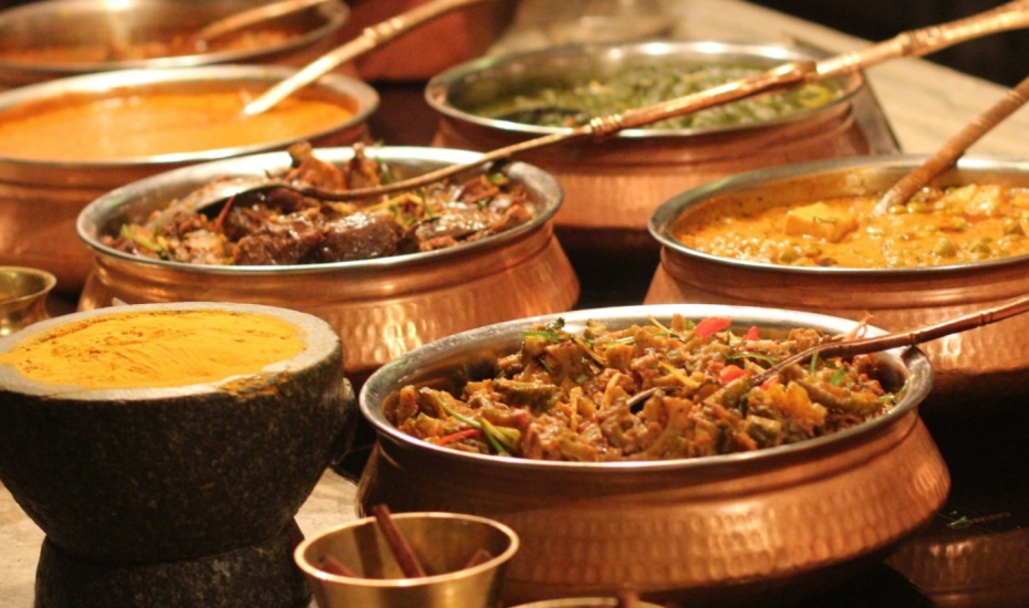 Authentic Indian food spread with curries, naan, and traditional copper serving bowls at Bombay Kitchen and Bar in Vancouver.