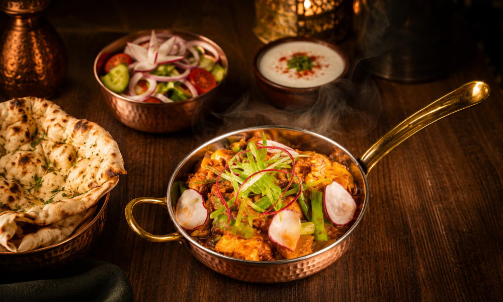 Chef's Special Mixed Veg featuring fresh seasonal vegetables sautéed in aromatic Indian spices, garnished with radish and scallions, served in a traditional copper bowl.