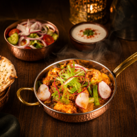 Chef's Special Mixed Veg featuring fresh seasonal vegetables sautéed in aromatic Indian spices, garnished with radish and scallions, served in a traditional copper bowl.